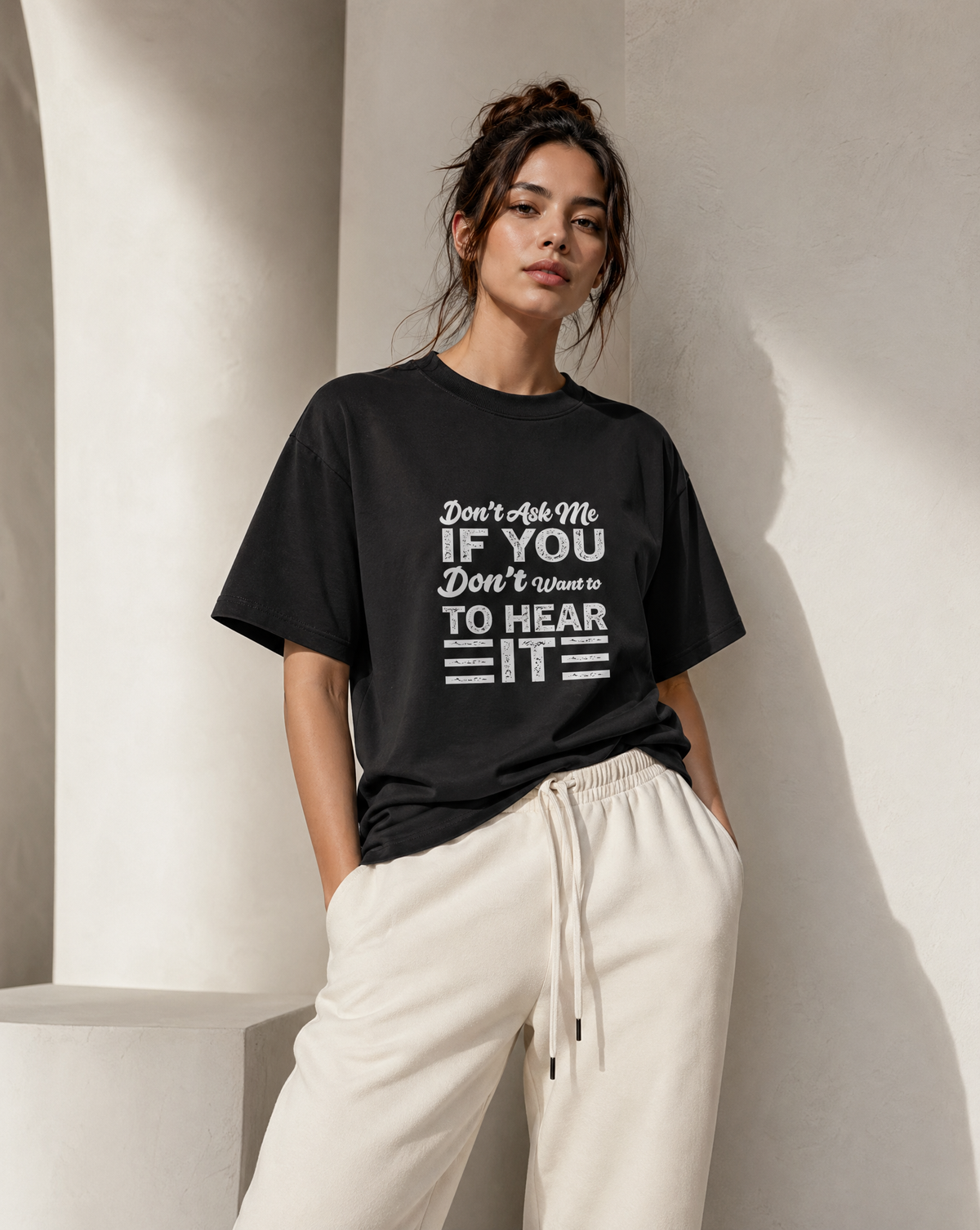 Person wearing a black t-shirt with text against a neutral background